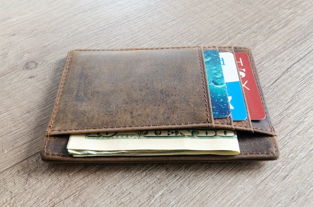 brown wallet with American cash and credit cards in it